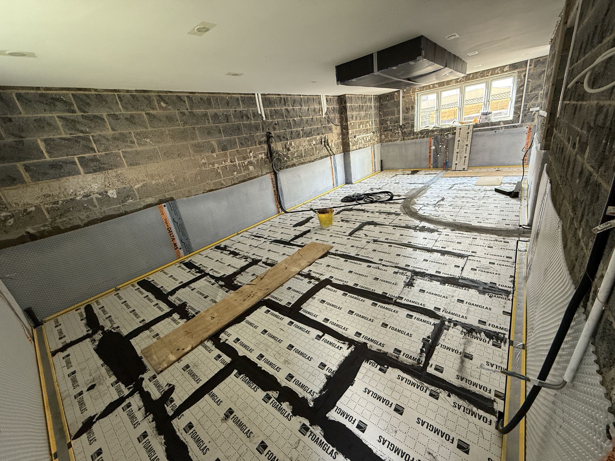 Second layer of 70mm Foamglas insulation bedded crossways over the first layer — giving a total of 120mm of insulation, impermeable and rot-proof, specified to Ciria C790